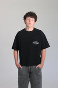 Model wearing boxy oversize hamby black t-shirt with hamby logo embroidered on the front left chest in white. T-shirt is 100% cotton, 240gsm. 