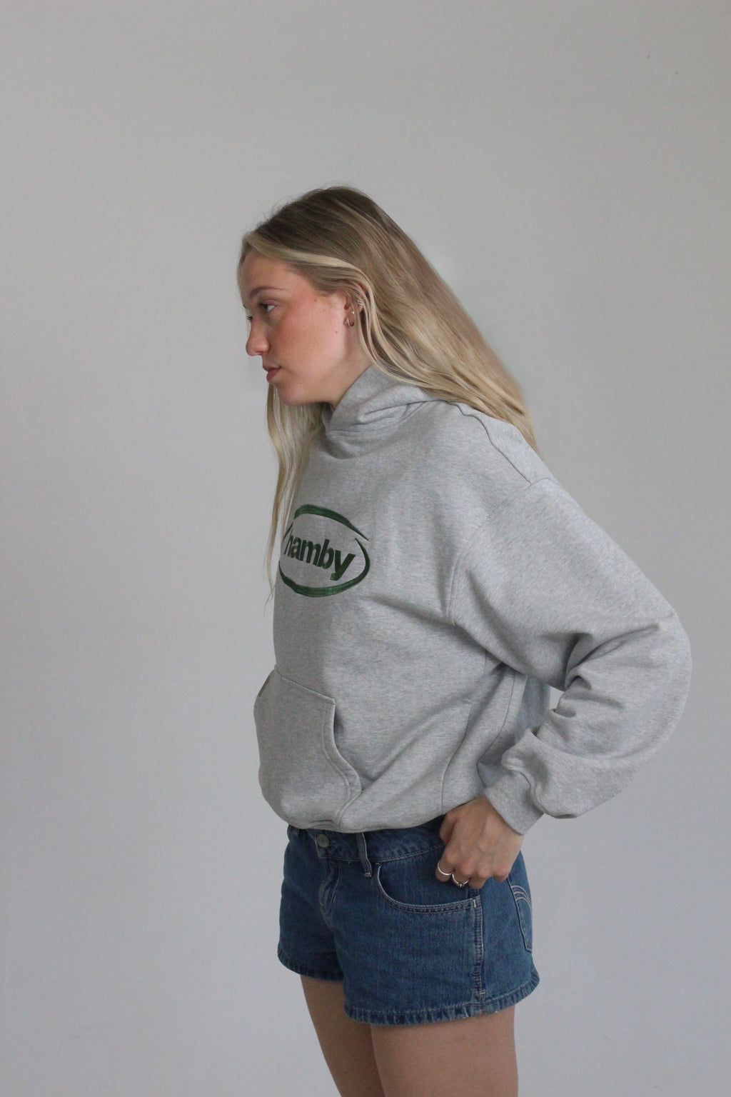 Model is wearing the hamby hoodie in ash grey. Hamby logo embroidery on centre chest in green. Hoodie is 480gsm, 100% cotton and it’s an oversize, slightly boxy fit. 