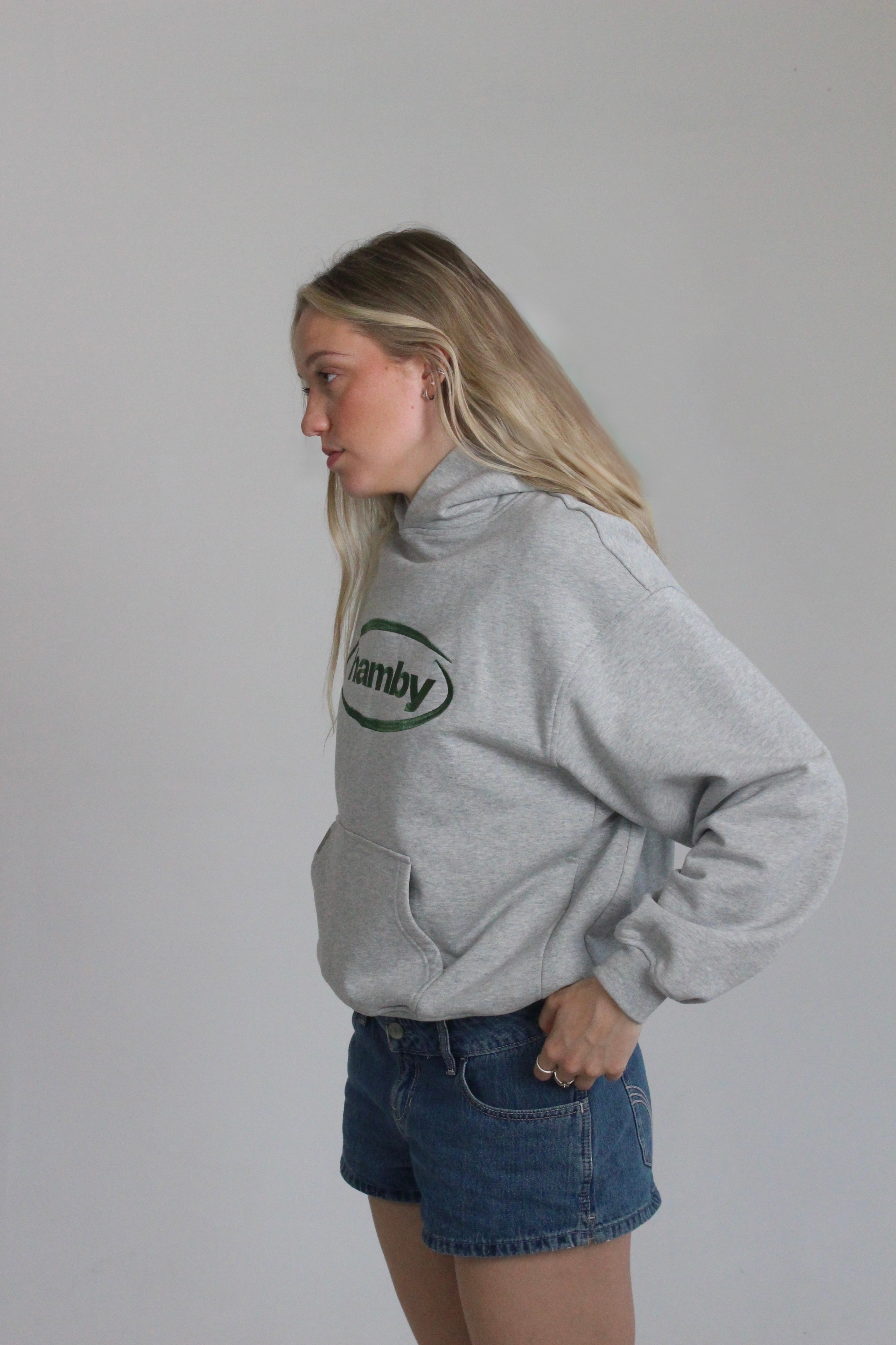 Model is wearing the hamby hoodie in ash grey. Hamby logo embroidery on centre chest in green. Hoodie is 480gsm, 100% cotton and it’s an oversize, slightly boxy fit. 