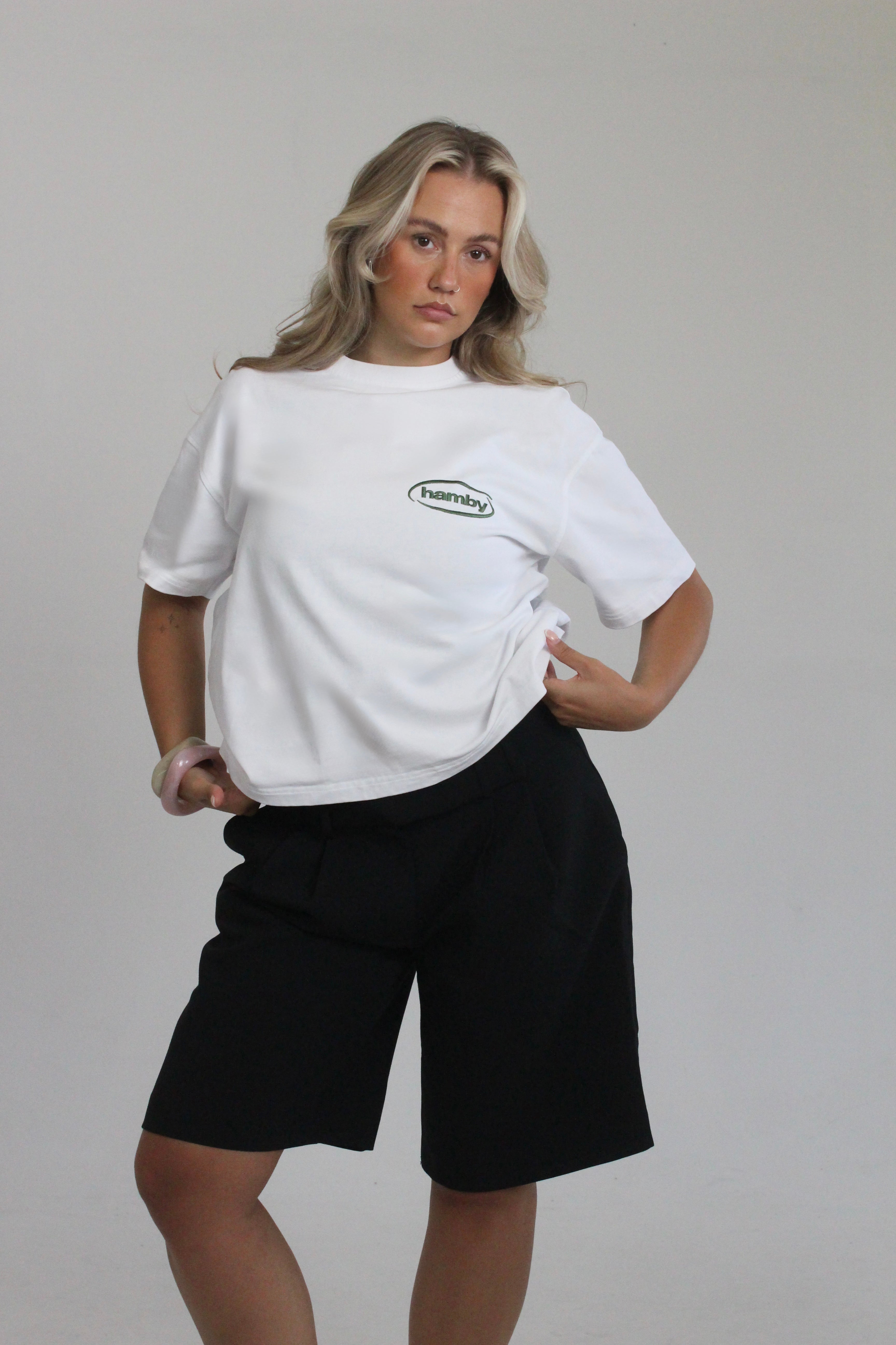 Model wearing hamby’s roll the dice tee in white. Oversize, boxy fit, 240gsm, 100% cotton. Hamby logo embroidered in green on front left chest. 
